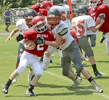 WRAPPED UP – Jr. Red Devils running back Will Clapper (2) gets met by a Gleason defender, during a first quarter run on Saturday. The Jr. Red Devils started their season with a 22-0 win at home over the Jr. Bulldogs. (Photo by Charles Choate)