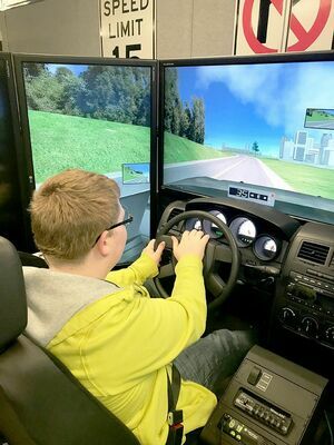 STUDENTS IN THE DRIVER’S SEAT – Fulton Independent 8th grader Dorian Bradberry takes his turn at the Fulton County Transit Authority Driving Simulator under the direction of Safety Trainer Keith St. John made possible by the Juvenile Justice Fiscal Incentive Program Grant (JJFIP). (Photo submitted)