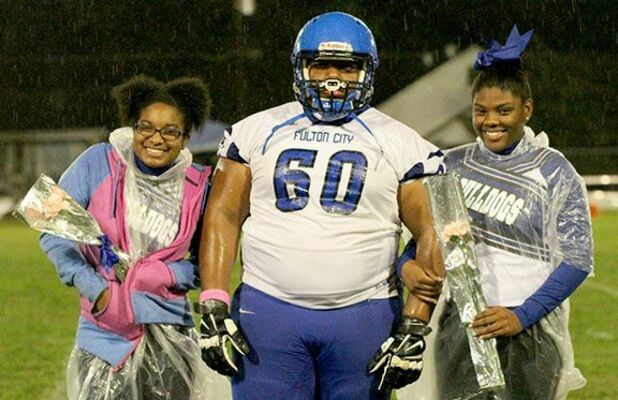 SENIOR NIGHT – Fulton Independent Schools celebrated Senior Night before the final home football game last Friday. Despite a pouring rain, fans showed up to honor three Bulldogs for their contributions to athletics. Pictured, left to right, are cheerleader Zakira Donald, football player Keith Martin and cheerleader Kereni Ware, who were introduced during pre-game midfield ceremonies. (photo by Charles Choate)