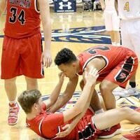 TEAMWORK – Down with a leg cramp, SFHS Red Devil Beau Britt is assisted by teammate Blake Johnson during court action versus Union City. (Photo by Jake Clapper.)