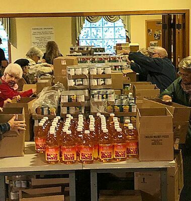 Foodbank volunteers sort and prepare the many boxes of food items distributed each month locally.