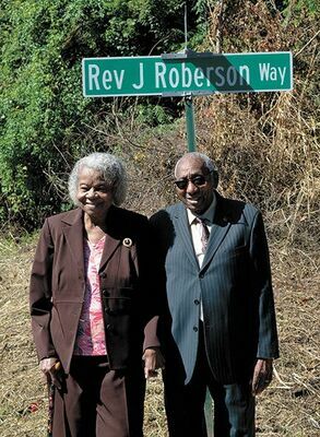 HIS “WAY”, IN THIS PHOTO PUBLISHED IN THE CURRENT OCT. 16– Rev. James Roberson, right, was honored by the City of Hickman with the renaming of Fourth Street to Rev. James Roberson Way on Oct. 12. Family and members of the community gathered for the unveiling. Roberson and his wife Bernice stand under the new street sign at the corner of Ivey and Rev. James Roberson Way. (Photo by Barbara Atwill)