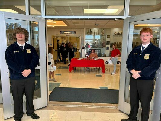GREETERS FOR VETERANS DAY - Connor O'Malley and Jason Mathews, Fulton County FFA Officers, stood at the doors and welcomed visitors to the Fulton County School's Veterans Day program held Nov. 10, in the gymnasium of Fulton County High School. (Photo submitted)