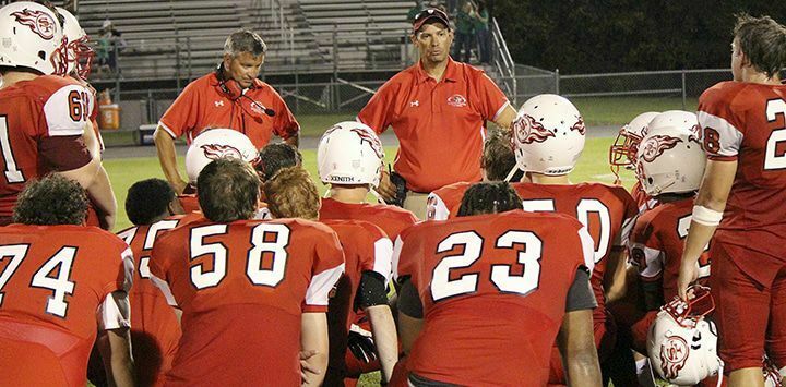 TEAM MEETING – South Fulton coaches Brent Wilson (center) and Jason Rodehaver (left) talk to the team following their Friday night game. Three failed extra point conversions proved to be the difference in the game for the Red Devils, as Greenfield escaped with a 19-18 win at home. (Photo by Charles Choate)
